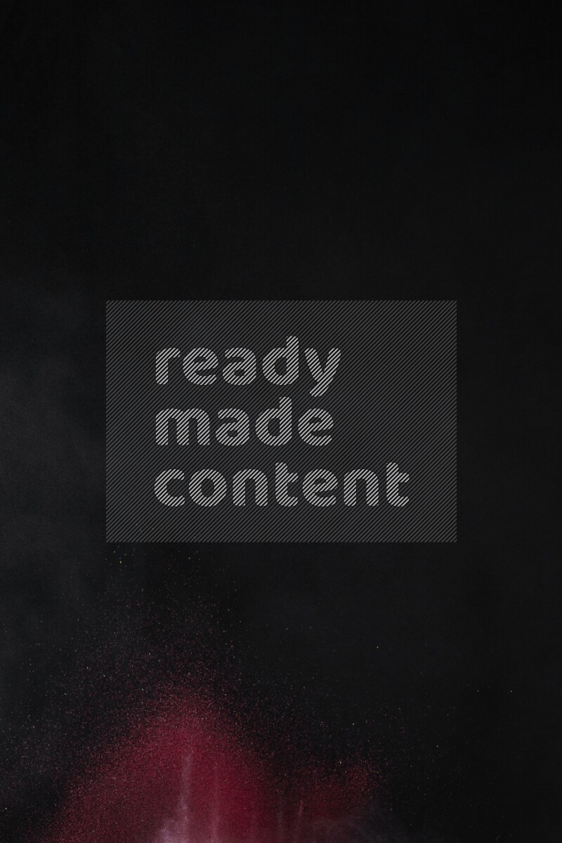 A side view of red powder explosion on black background