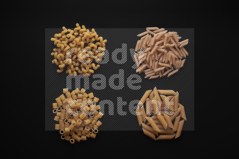 Different pasta types in bunches on black background