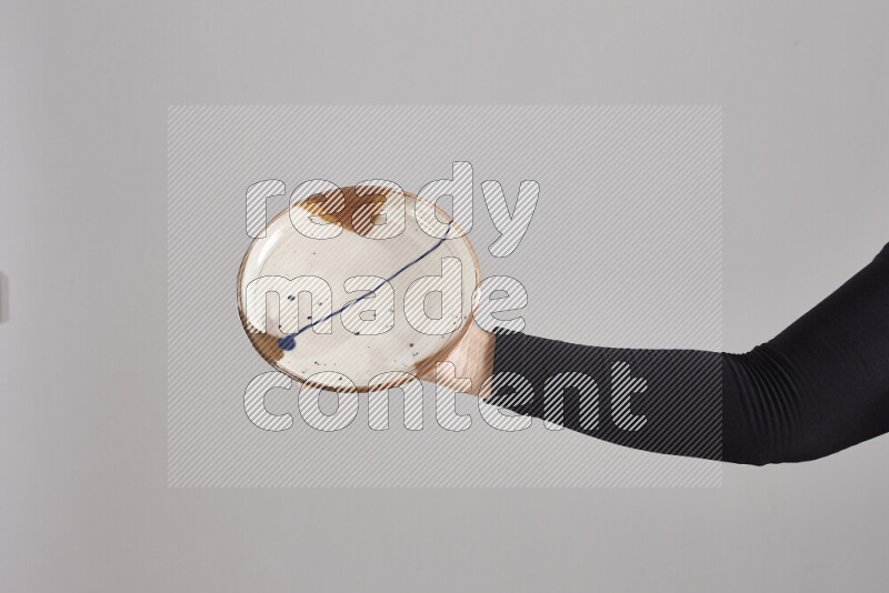 A woman in black abaya holding different pottery essentials in different positions