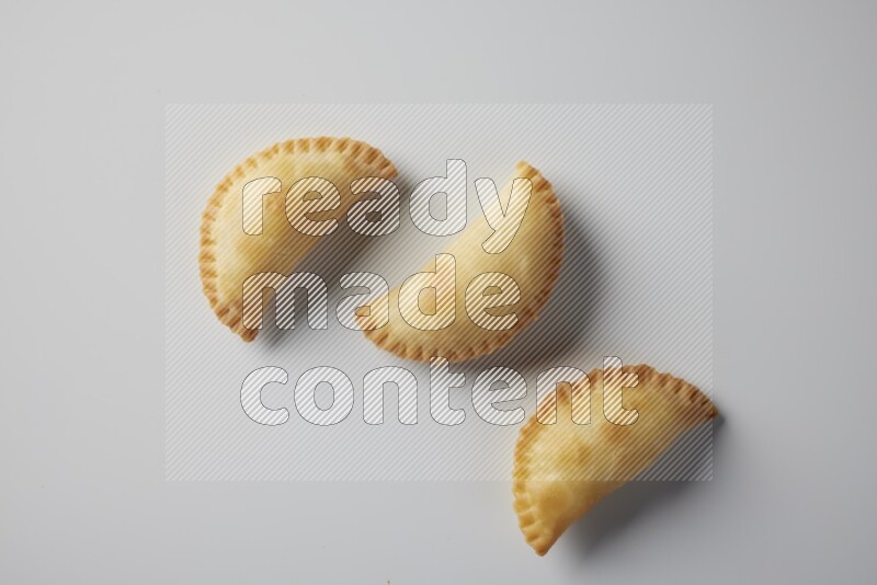 Three fried sambosa from a top angle on a white background