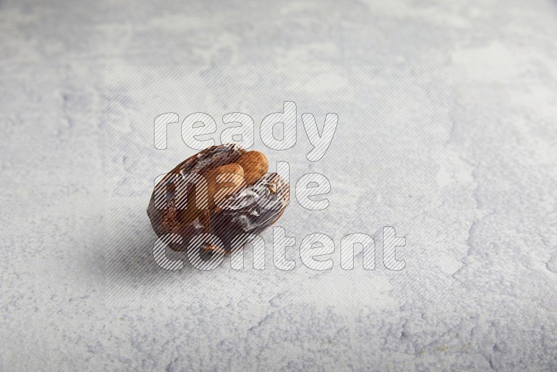 almond stuffed madjoul date on a light grey background