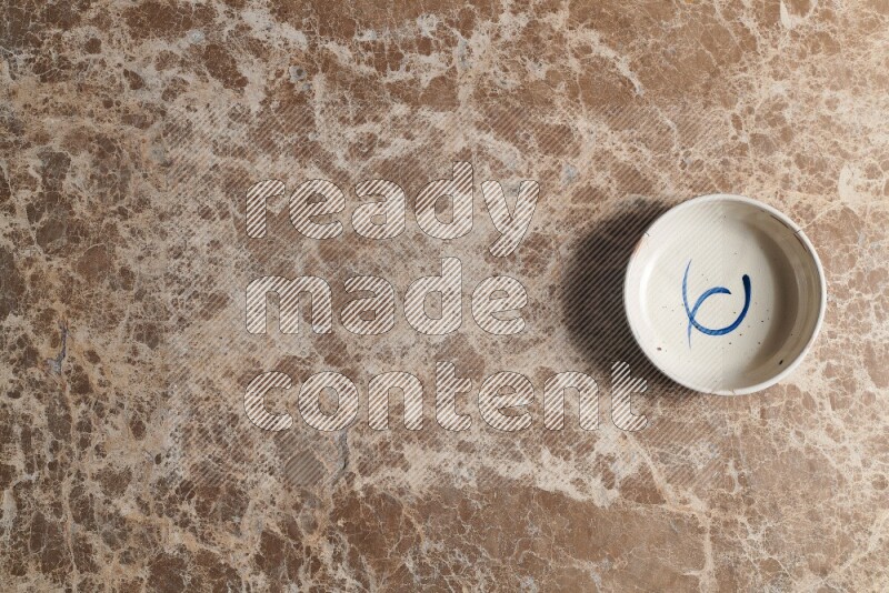 وعاء فخاري متعدد الألوان على خلفية من الرخام البيج