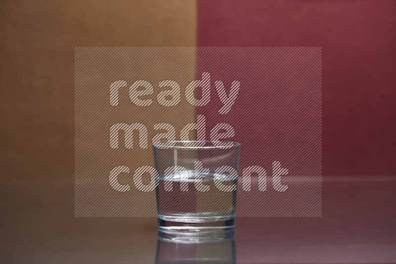 The image features a clear glassware filled with water, set against brown and dark red background