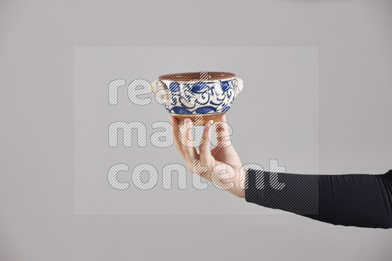 A woman in black abaya holding different pottery essentials in different positions
