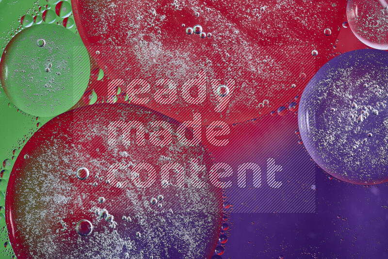 لقطات مقربة لفقاعات من الزيت على سطح الماء باللون الأرجواني والأخضر والأحمر