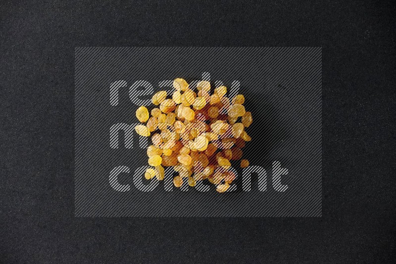 Yellow raisins isolated on a black background in different angles