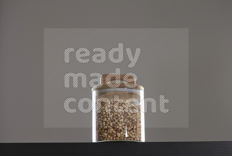 Black-eyed peas in a glass jar on black background