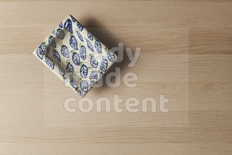 صحن فخاري مزخرف على خلفية خشبية فاتحة