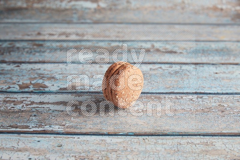 45º Shot of Brown Hazelnuts macaron on light blue wooden background