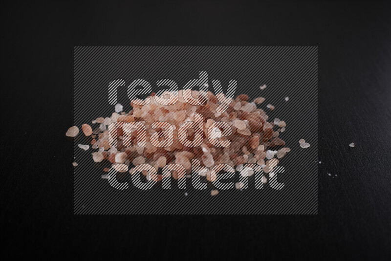 A bunch of coarse himalayan salt crystals on black background