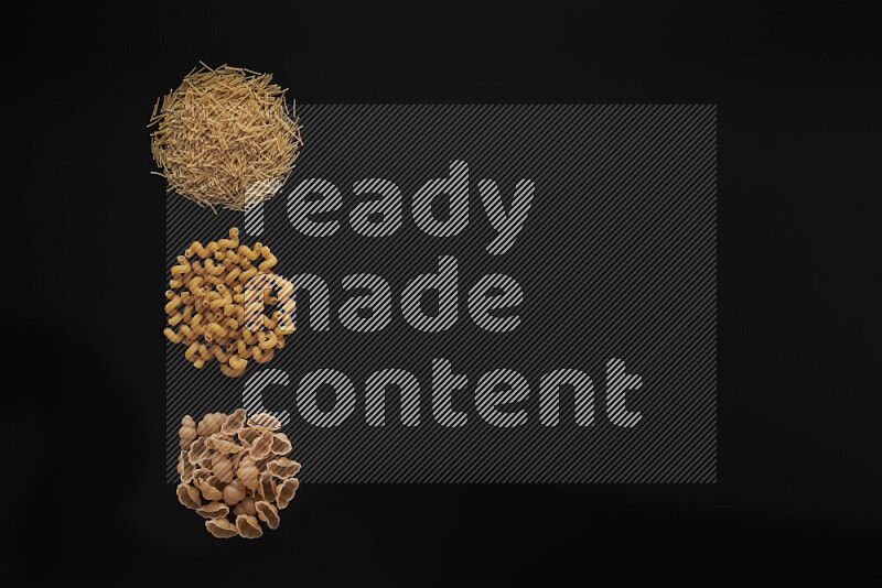 Different pasta types in 3 bunches on black background