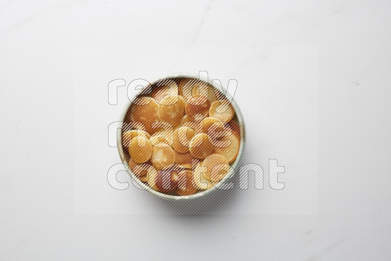 Top-view shot of plain cereal pancakes in a round bowl on white background
