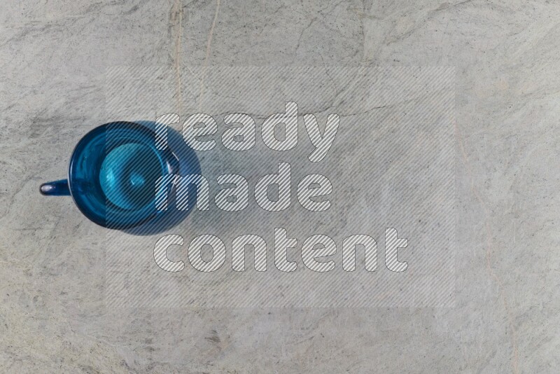 A colored glass jug on grey marble background