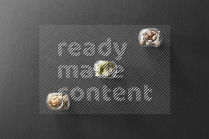 أوراق الغار وزنجبيل مجفف وجوزة الطيب في أوعية زجاجية علي خلفية سوداء