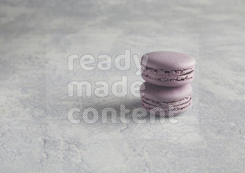 45º Shot of two Purple Blueberry macarons  on white  marble background