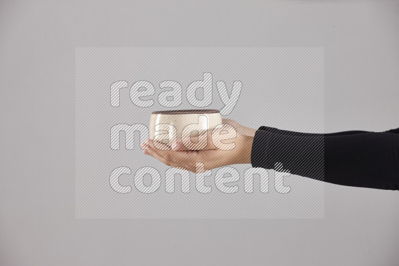 A woman in black abaya holding different pottery essentials in different positions