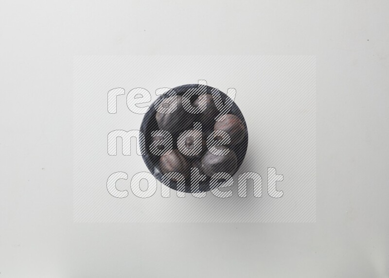 Top-view shot of dried lime (loomi) in a container on white background