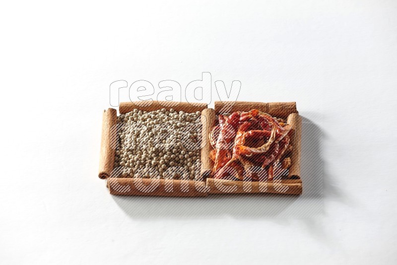 2 squares of cinnamon sticks full of red dried chilis and white pepper on white flooring