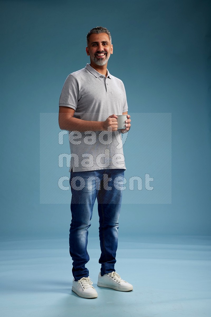 Man Standing drinking coffee on blue background
