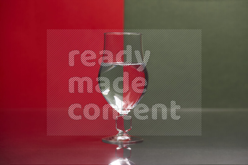 The image features a clear glassware filled with water, set against red and dark green background