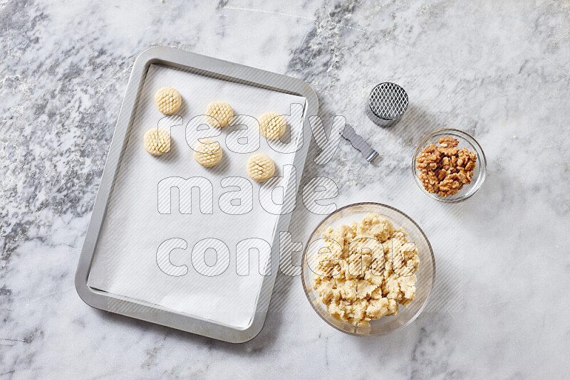 Kahk step by step with its ingredients ghee, sugar, flour, sesame, yeast, water and kahk flavor on grey marble background