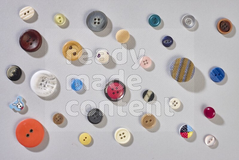 Mixed assorted buttons on grey background