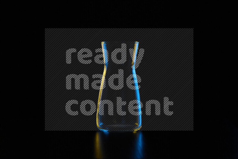 Glassware with rim light in blue and yellow against black background