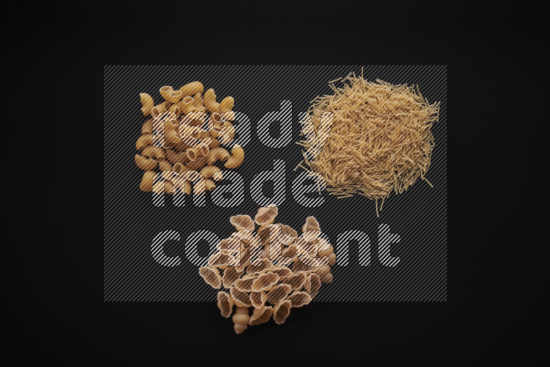 Different pasta types in bunches on black background
