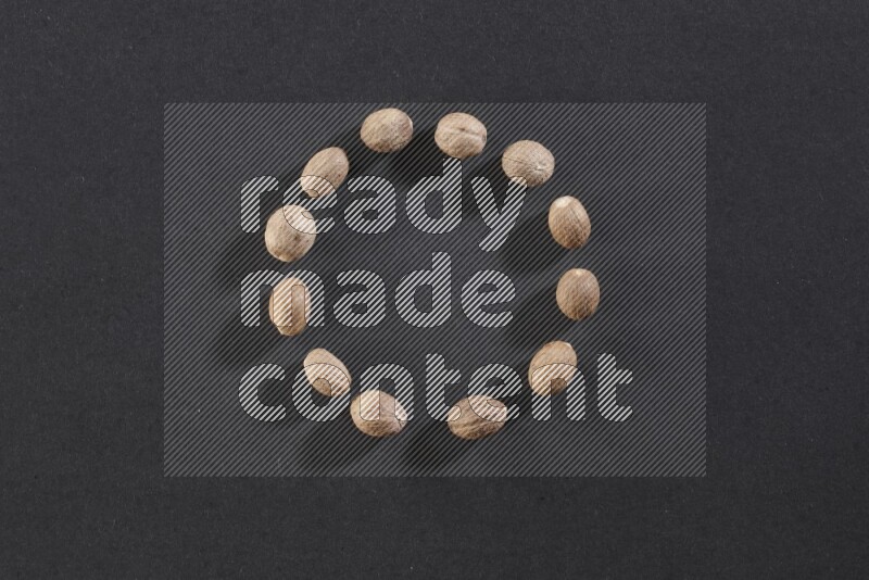 Nutmeg in a circle shape on a black flooring in different angles