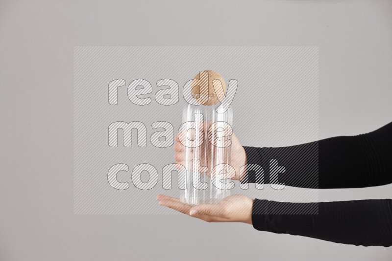 A woman in black abaya holding different glassware in different positions