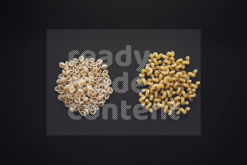 Different pasta types in bunches on black background