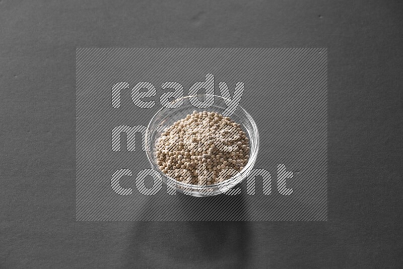 فلفل أبيض في وعاء زجاجي علي خلفية سوداء