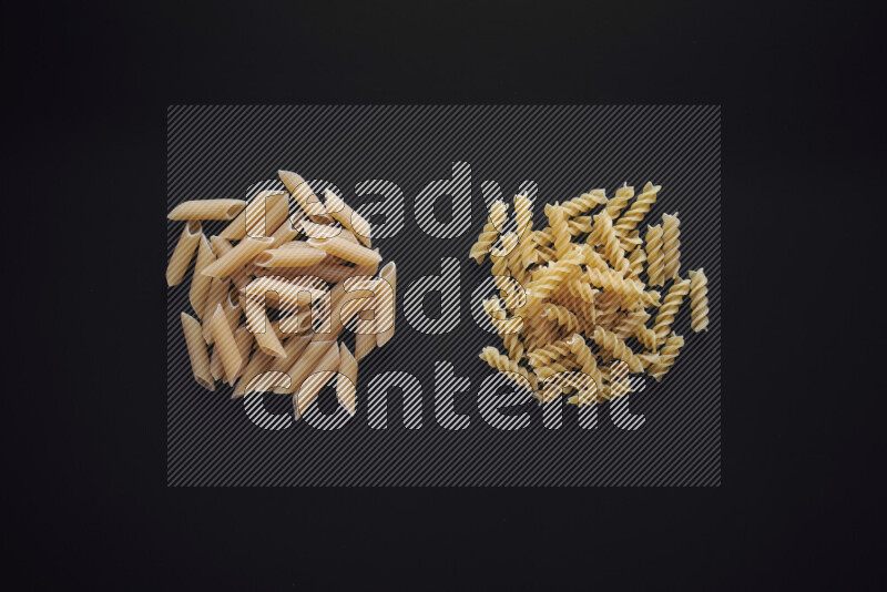 Different pasta types in bunches on black background