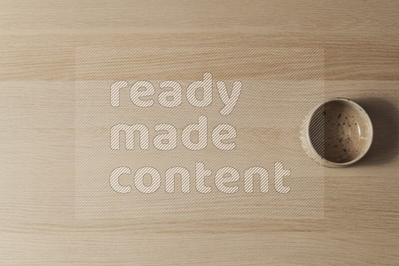 A multicolored pottery bowl on light wooden background