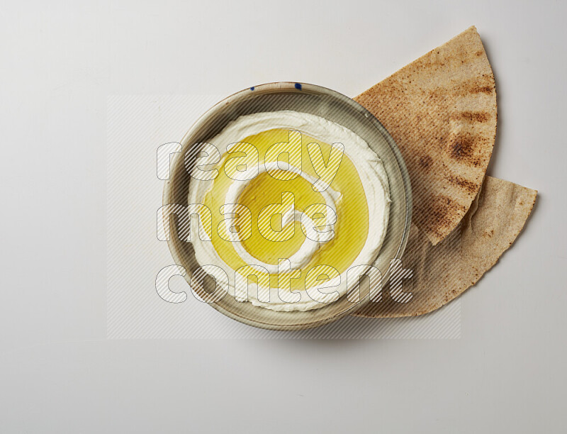 Lebnah garnished with olive oil in a grey pottery plate on a white background