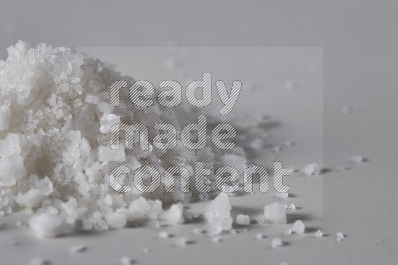 A bunch of coarse sea salt crystals on white background