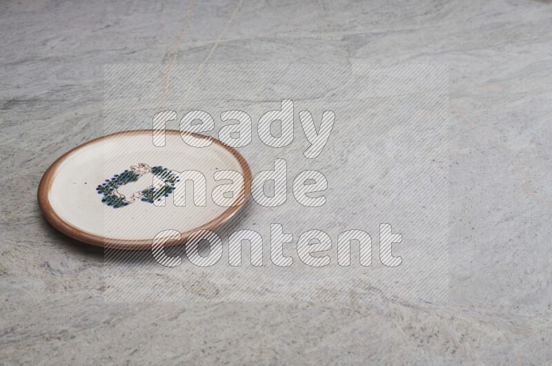 A decorative pottery plate on grey marble background