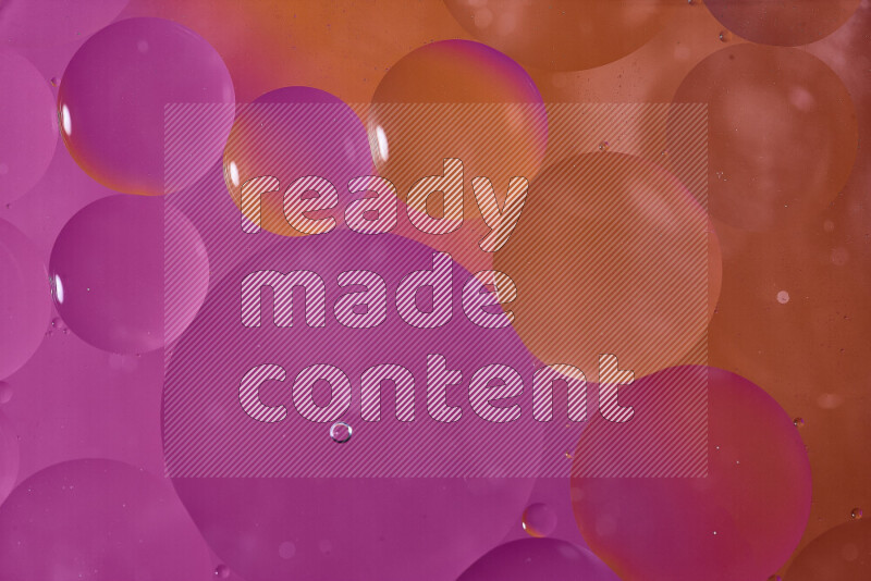 Close-ups of abstract oil bubbles on water surface in shades of orange and pink