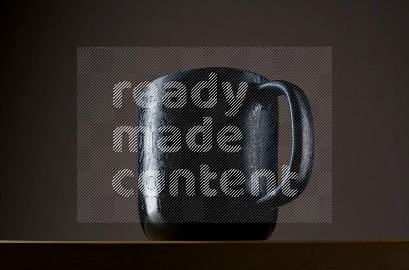 Low angle shot of a black cup on grey background