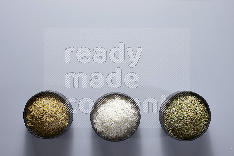 Legumes in pottery bowls on light grey background