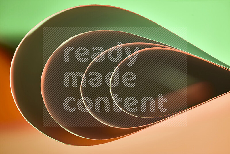 An abstract art of paper folded into smooth curves in green and orange gradients