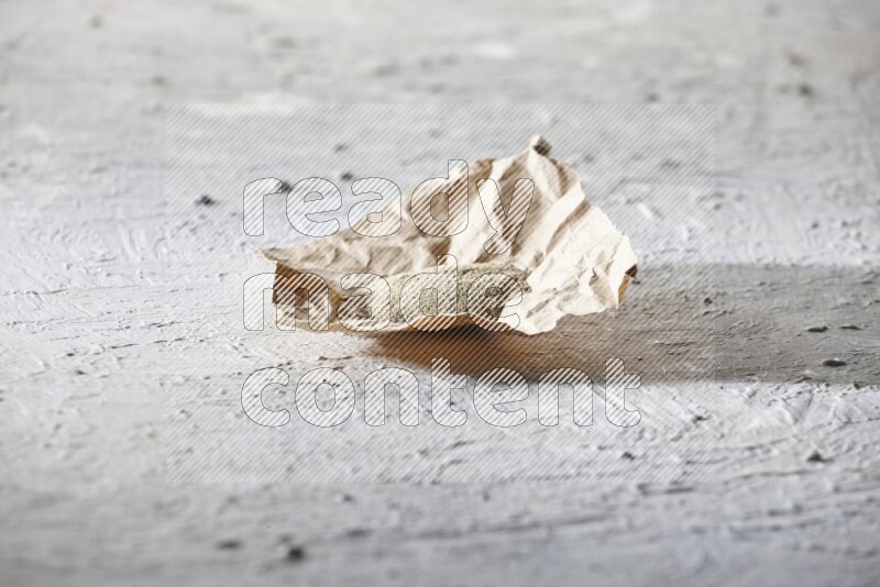White pepper powder in a crumpled piece of paper on textured white flooring
