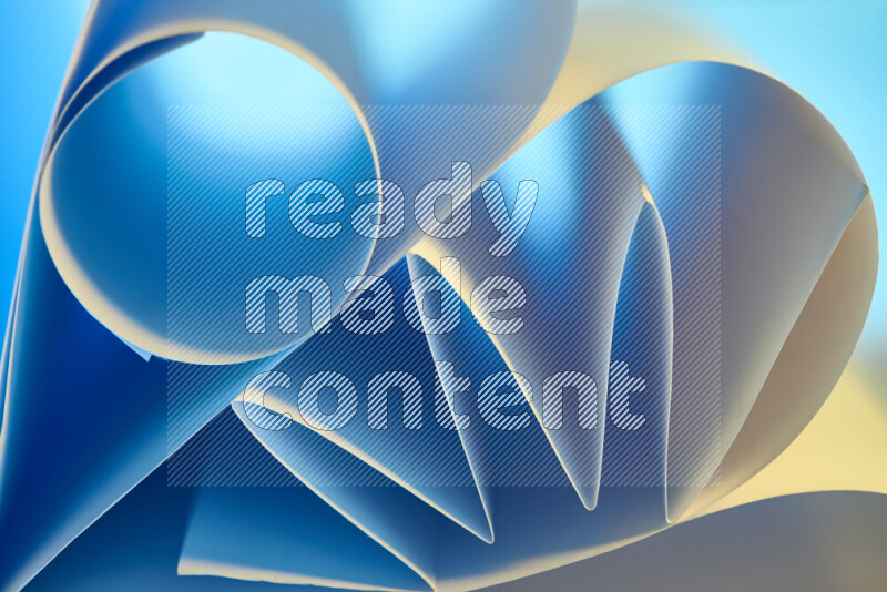 عرض فني لطيات الورق تخلق مزيج من الأشكال الهندسية، مضاءة بإضاءة ناعمة بدرجات اللون الأزرق والالوان الدافئة