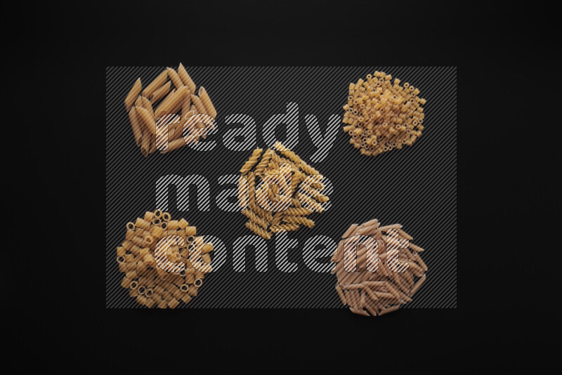 Different pasta types in bunches on black background
