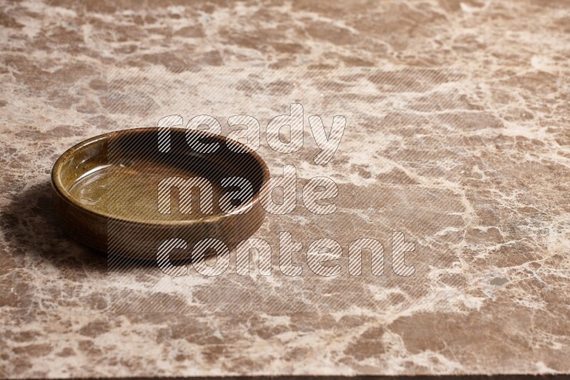 A multicolored pottery oven plate on beige marble background