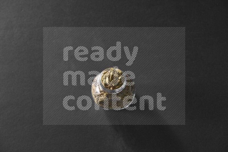 هيل في وعاء زجاجي علي خلفية سوداء