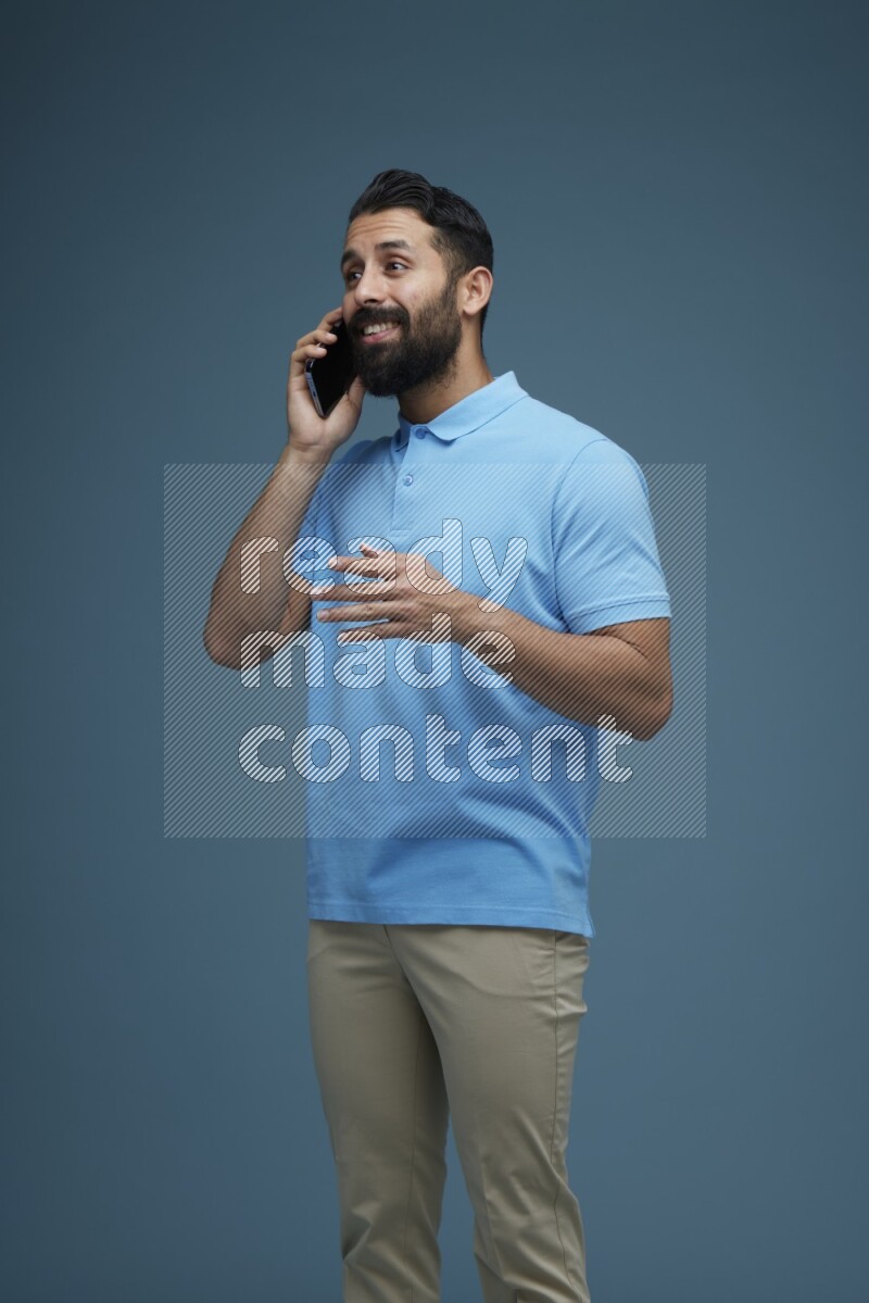 A man having a Call in a blue background wearing a Blue shirt