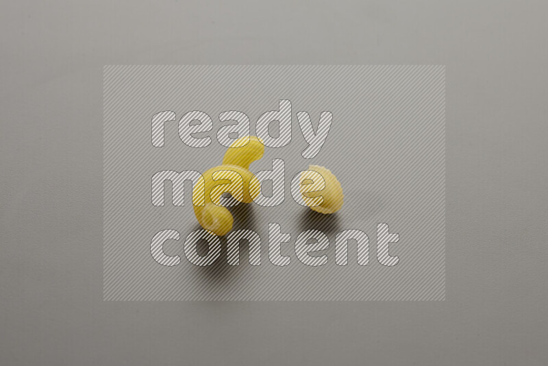 Twist pasta with other types of pasta on grey background