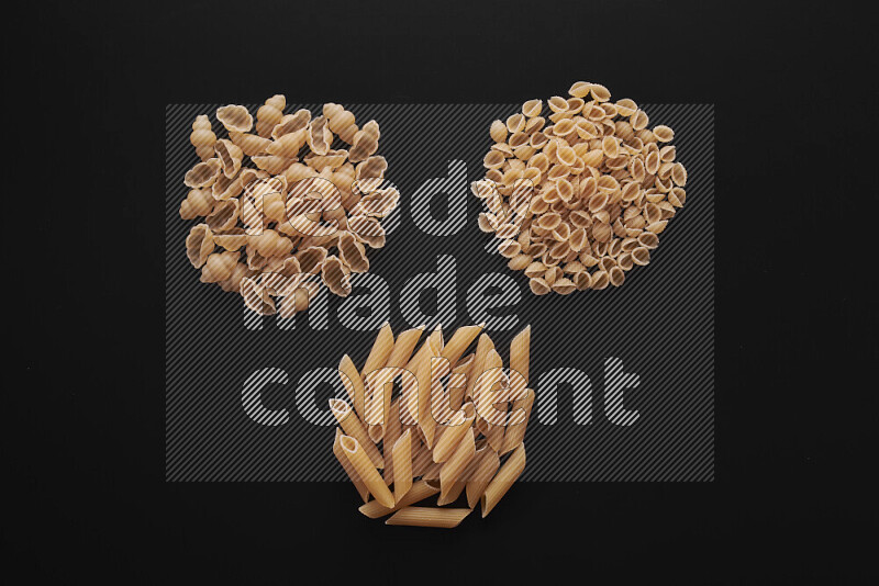 Different pasta types in bunches on black background