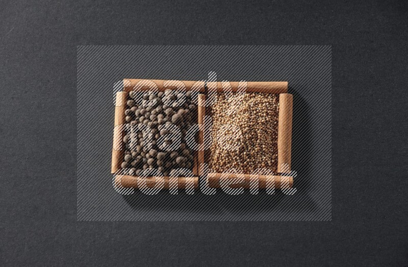 2 squares of cinnamon sticks full of mustard seeds and allspice on black flooring